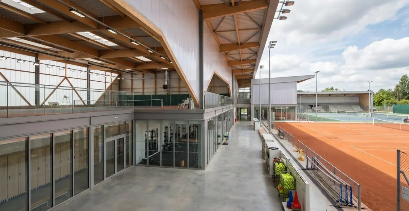 Centre d'entraînement tennis avec courts intérieurs et extérieurs, espaces de préparation physique